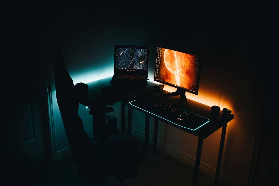 Sleek black gaming recliner with lumbar support and cup holders in a dark gaming setup