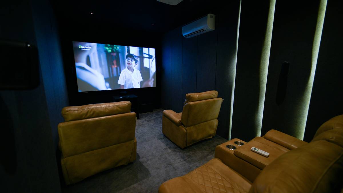 Close-up of ergonomic home theater recliner seats showing adjustable lumbar support and armrest controls